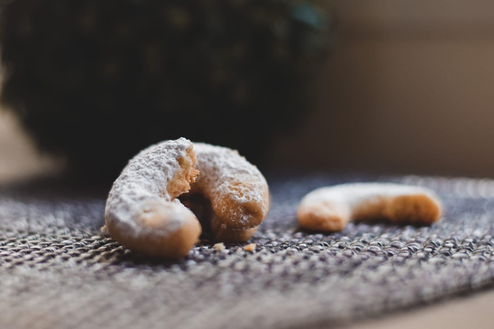 A Vanilla Almond cookie broken open showing its soft interior, dusted with powdered sugar